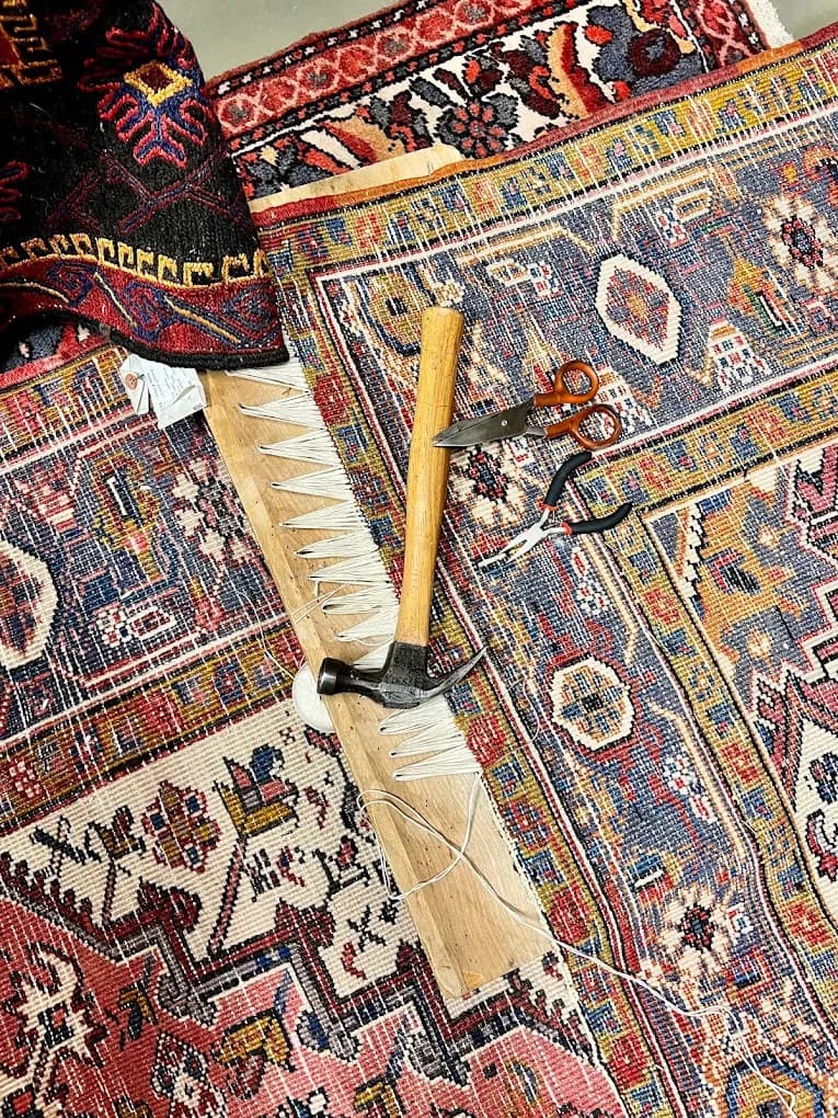 Fringe repair on an oriental rug, with a hammer, shears, and pliers